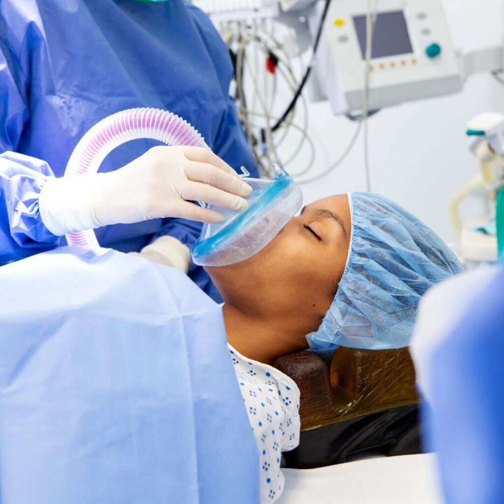 A CRNA administering anesthesia to a patient