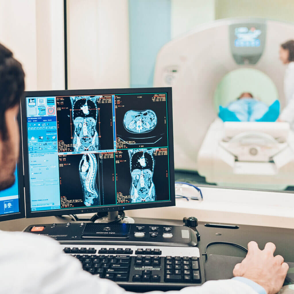 An MRI technician supervises a procedure